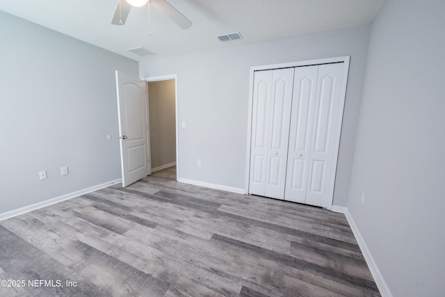 unfurnished bedroom featuring ceiling fan, light hardwood / wood-style floors, a textured ceiling, and a closet