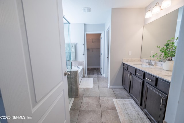 bathroom with tile patterned floors, vanity, and walk in shower