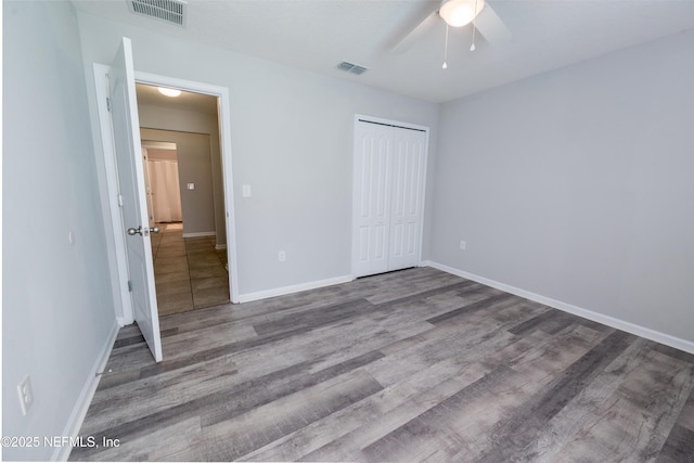 unfurnished bedroom featuring ceiling fan, a closet, and hardwood / wood-style floors