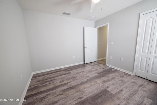 unfurnished bedroom with wood-type flooring, a closet, and ceiling fan