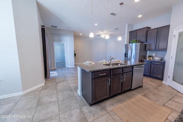 kitchen featuring pendant lighting, a center island with sink, sink, dark brown cabinetry, and stainless steel appliances