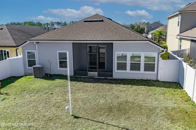 back of property with central air condition unit and a yard