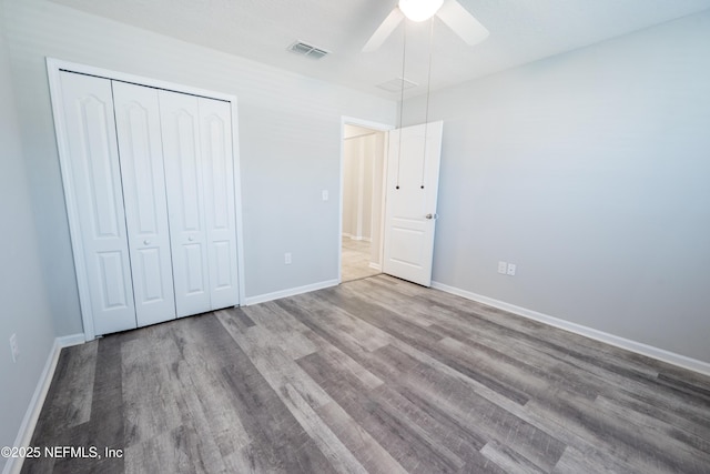 unfurnished bedroom with ceiling fan, a closet, and hardwood / wood-style flooring