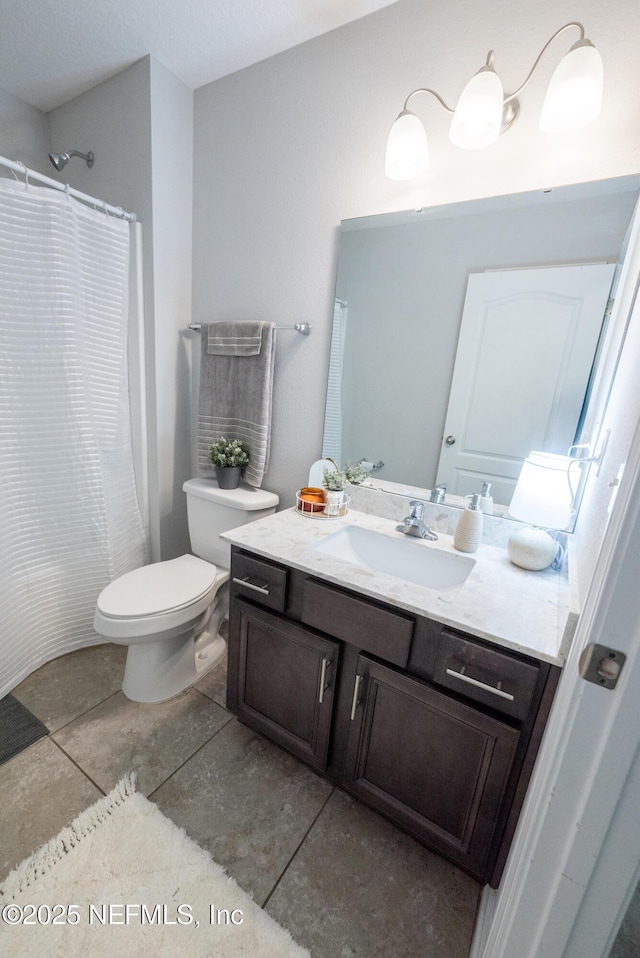 bathroom with tile patterned flooring, vanity, and toilet