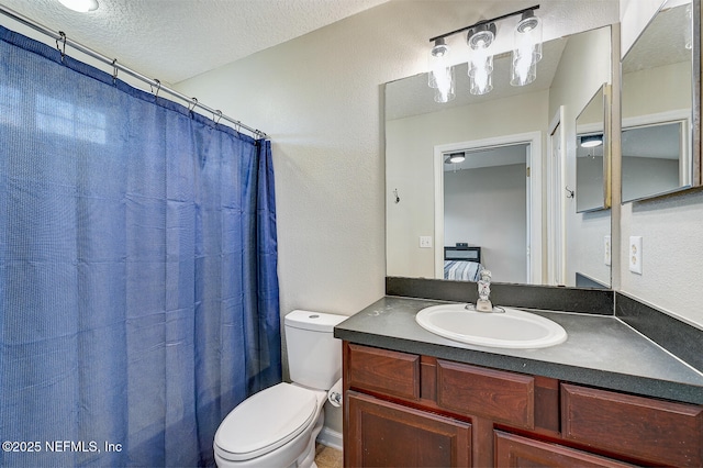 bathroom featuring vanity, a textured ceiling, and toilet