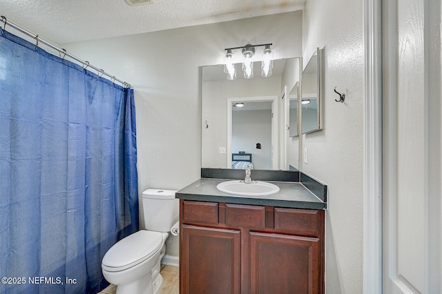 bathroom with vanity, a textured ceiling, and toilet