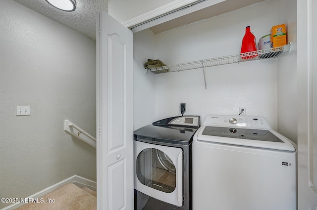 clothes washing area with a textured ceiling and washing machine and clothes dryer