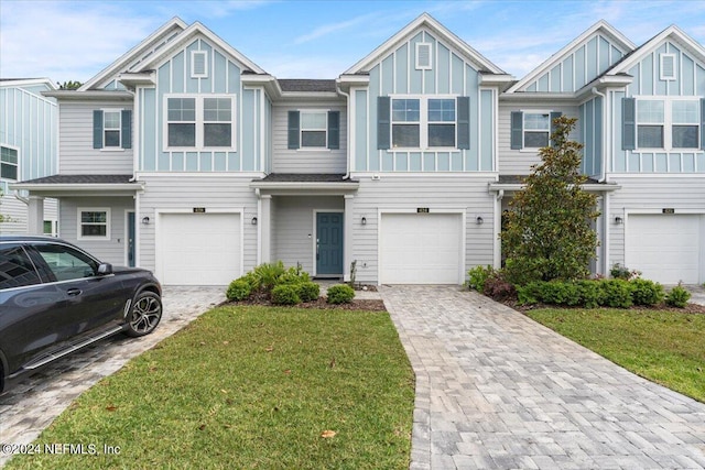 view of property with a garage and a front lawn