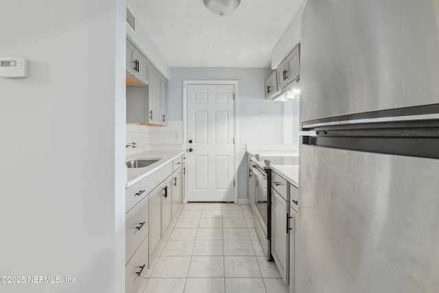 kitchen with tasteful backsplash, light countertops, visible vents, appliances with stainless steel finishes, and a sink