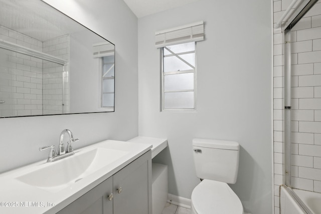 bathroom with toilet, baseboards, combined bath / shower with glass door, and vanity