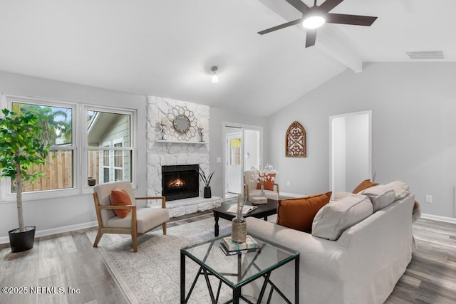 living room featuring a fireplace, ceiling fan, lofted ceiling with beams, and wood-type flooring