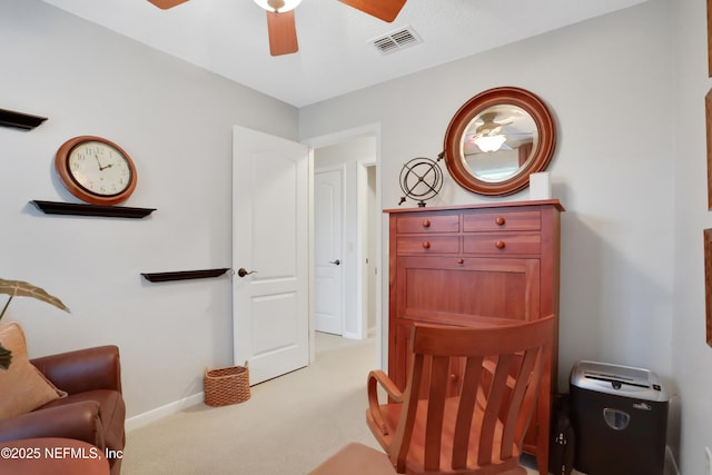 living area featuring light carpet and ceiling fan