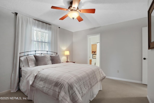 bedroom featuring light carpet, a textured ceiling, ensuite bath, and ceiling fan