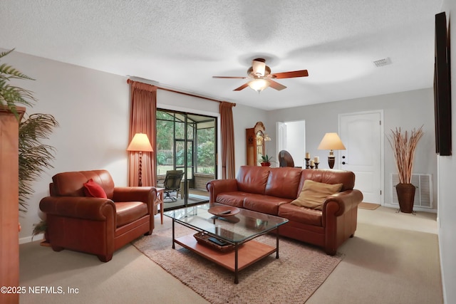 living room featuring a textured ceiling, light colored carpet, and ceiling fan