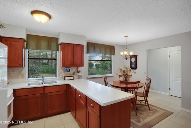 kitchen featuring sink, pendant lighting, light tile patterned floors, a chandelier, and range