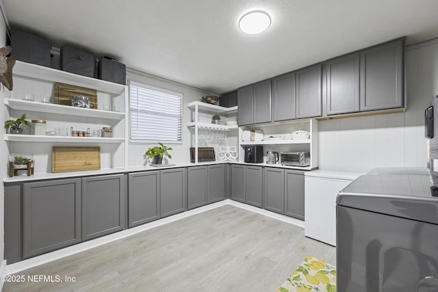 washroom featuring cabinets, a textured ceiling, and light hardwood / wood-style flooring