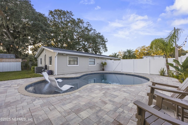 view of swimming pool with central air condition unit, a patio, and a storage shed