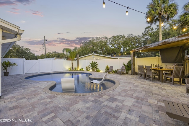 pool at dusk with a patio