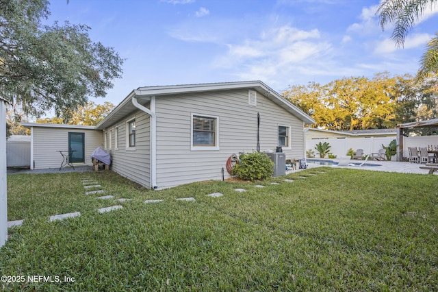 rear view of house featuring a lawn, a patio area, and cooling unit