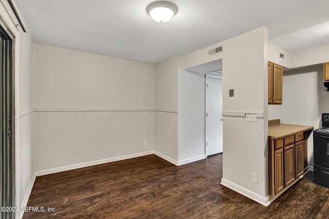 kitchen with dark wood-type flooring, electric range, and a textured ceiling