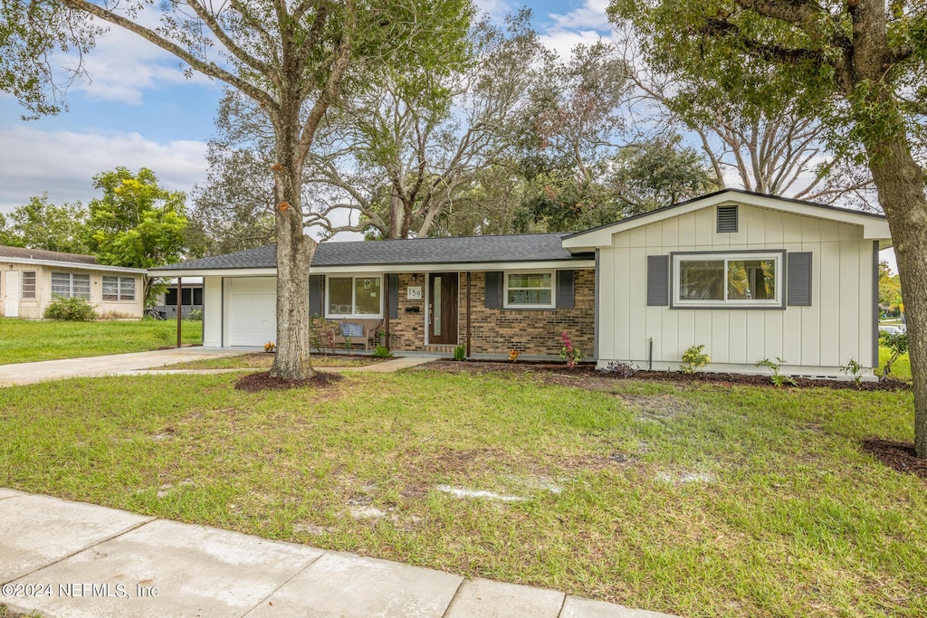 single story home featuring a front lawn and a garage