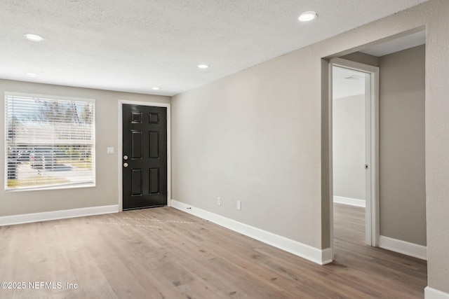 foyer with a textured ceiling and light wood-type flooring