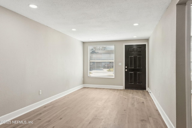 entryway featuring a textured ceiling and light hardwood / wood-style flooring