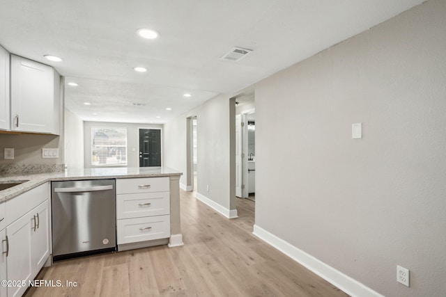 kitchen featuring kitchen peninsula, light hardwood / wood-style flooring, stainless steel dishwasher, light stone counters, and white cabinetry