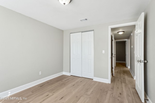 unfurnished bedroom featuring light hardwood / wood-style flooring and a closet