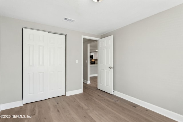 unfurnished bedroom with light hardwood / wood-style floors and a closet