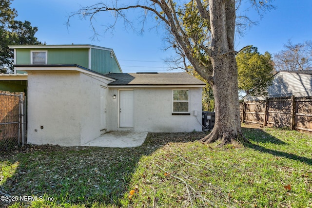 rear view of property with central AC unit, a yard, and a patio