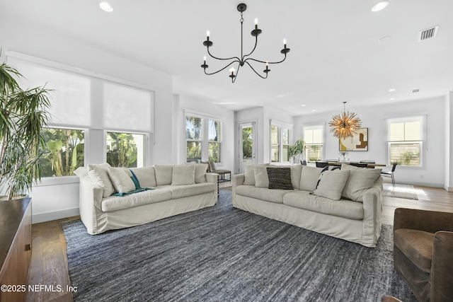 living room with dark wood-type flooring and an inviting chandelier