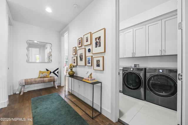 washroom featuring hardwood / wood-style flooring, cabinets, and washer and dryer