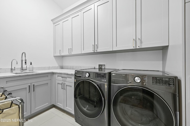 laundry room featuring light tile patterned flooring, cabinets, separate washer and dryer, and sink