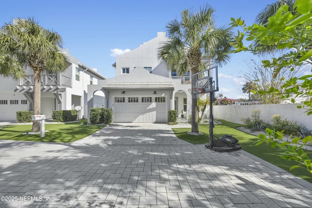 mediterranean / spanish house featuring a balcony, a garage, and a front yard