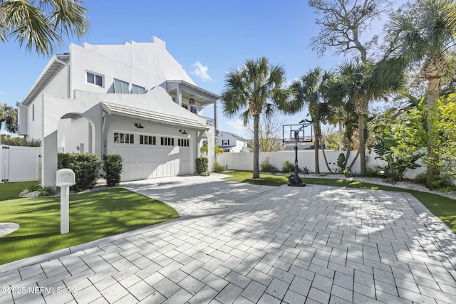 view of home's exterior with a garage, a yard, and a balcony