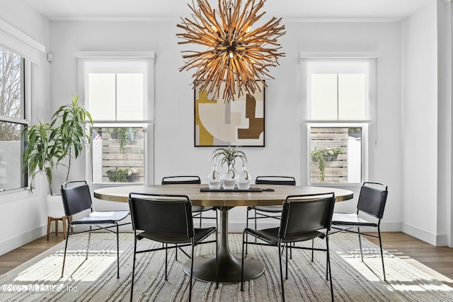 dining space with ornamental molding and hardwood / wood-style floors