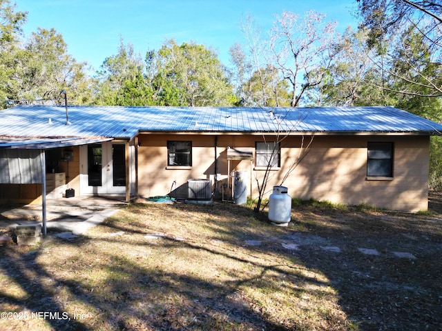 rear view of house with french doors, a yard, and cooling unit