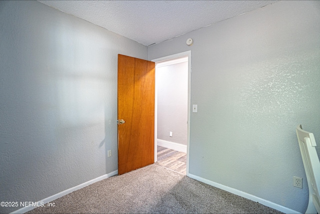 empty room featuring carpet and a textured ceiling