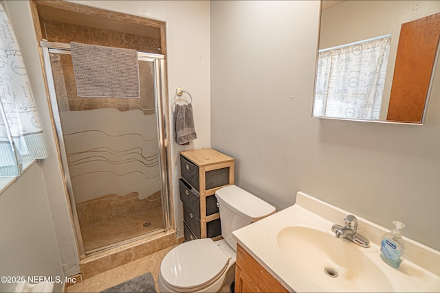 bathroom featuring tile patterned floors, toilet, vanity, and walk in shower