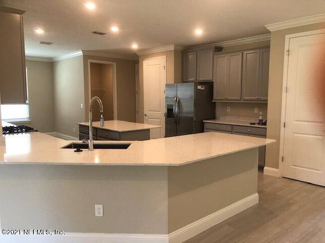 kitchen with a kitchen island with sink, sink, refrigerator with ice dispenser, wood-type flooring, and gray cabinets