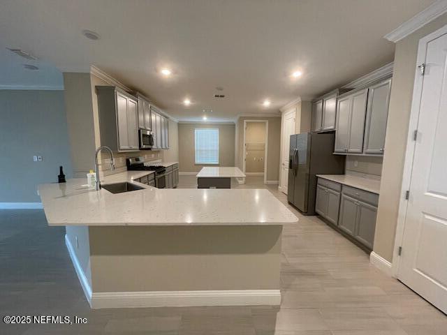 kitchen featuring kitchen peninsula, appliances with stainless steel finishes, gray cabinets, and crown molding