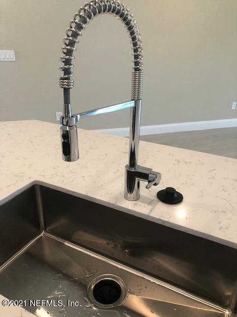 interior details with light stone countertops and sink