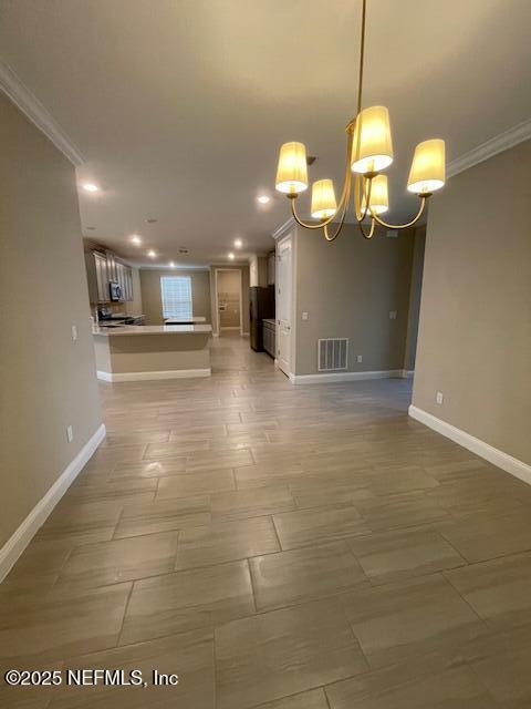 unfurnished room with crown molding and a notable chandelier