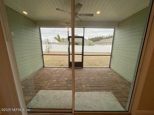 unfurnished sunroom with ceiling fan