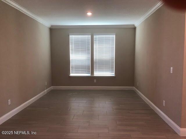 unfurnished room with dark wood-type flooring and ornamental molding