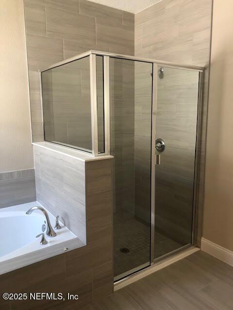 bathroom with plus walk in shower and hardwood / wood-style flooring