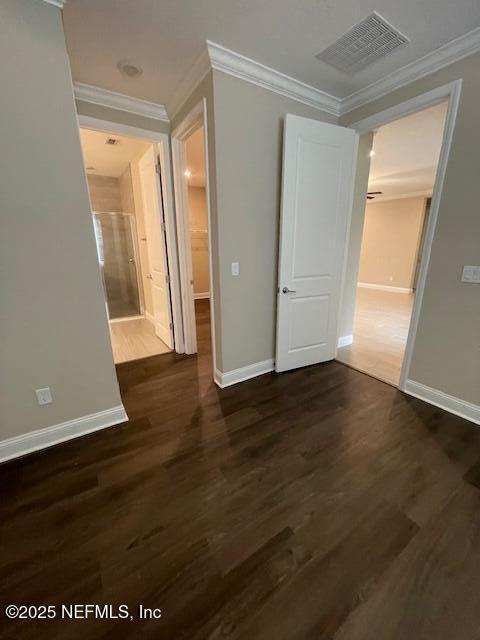 empty room featuring dark hardwood / wood-style flooring and ornamental molding