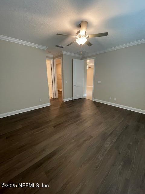 unfurnished bedroom featuring dark wood-type flooring, ceiling fan, and ornamental molding