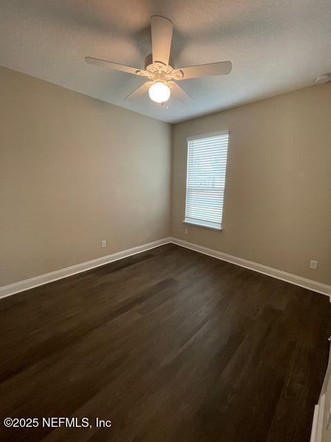 spare room with ceiling fan and dark hardwood / wood-style floors